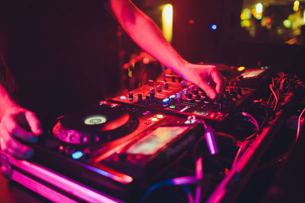 istock DJ turntable console mixer controlling with two hand in concert nightclub stage. 1163244370