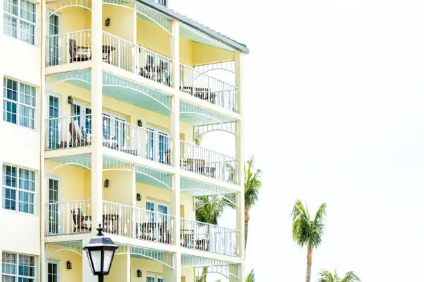 Pastel yellow orange green blue painted colorful architecture exterior of condo apartment building hotel resort in Florida beach home, pattern, many balconies