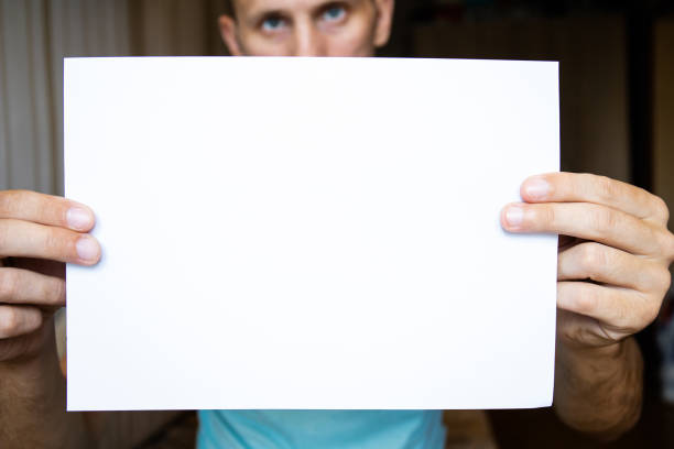 istock the guy holds a white sheet on outstretched hands, copy space 1163249574