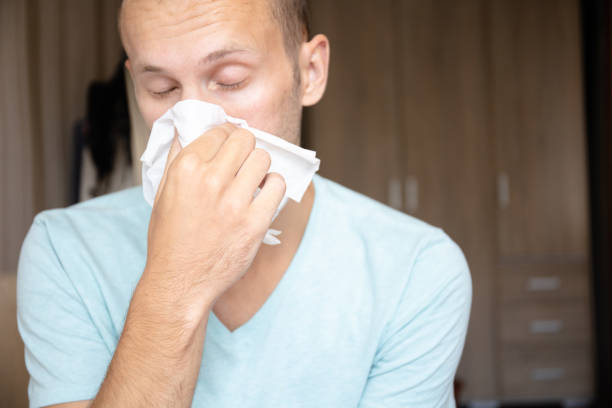 istock the guy blows his nose into a napkin 1163249584
