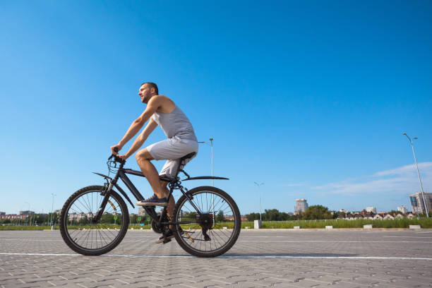 istock beautiful young guy with a bicycle against the sky on a sunny day 1163249659