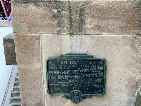 Sign commemorating the First Post Office of Chicago at the corner of Lake and Wacker at Wolf Point, hidden behind a wall