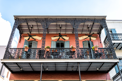 New Orleans, USA French quarter with wrought cast iron balcony of building in traditional architecture with potted plants decoration in Louisiana famous city