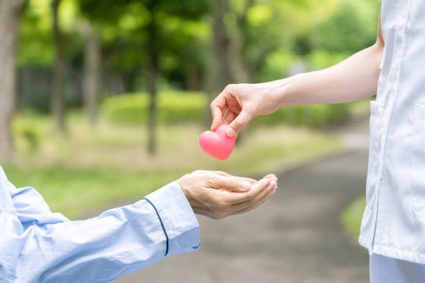 istock people holding heart symbol in park 1163255432