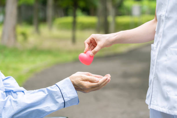 istock people holding heart symbol in park 1163255442