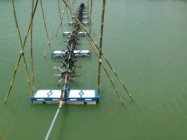 Photo of Turbine rotates the surface to increase oxygen in fish pond and shrimp pond. Turbine and shrimp farming techniques. Water oxygen generator.