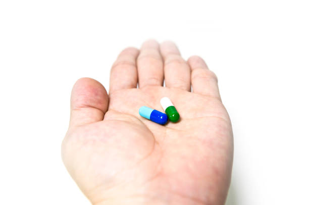 istock Drug combination therapy, Capsules on the patient's hand 1163258680