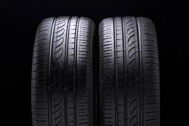 istock two used old summer tires on black background 1163258787