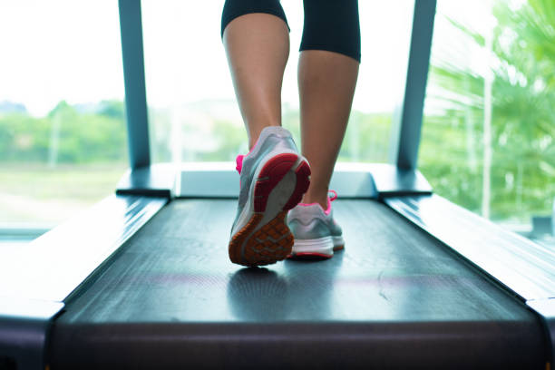 체육관에서 러닝 머신에 분홍색 운동화에 여성의 다리를 닫습니다 - treadmill 뉴스 사진 이미지