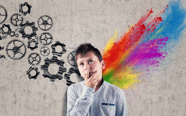 istock Thoughtful kid in front of a wall drawn and divided by brain hemispheres. Creative half and logical half. 1163268907