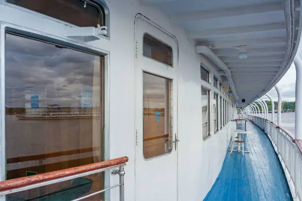 Deck of a ship with reflection of a passenger ship in the window, overcast