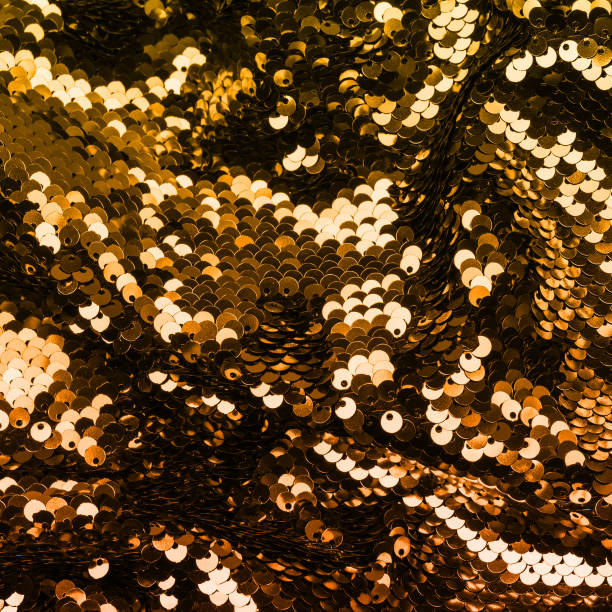 istock Golden iridescent sequins on fabric. Festive duotone background 1163278644
