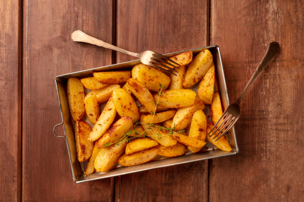 Potato wedges, oven baked with thyme, top shot on a baking sheet