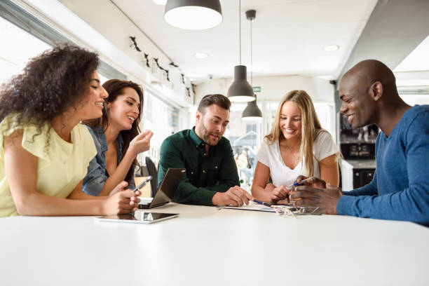 istock Multi-ethnic group of young people studying together on white desk 1163288136