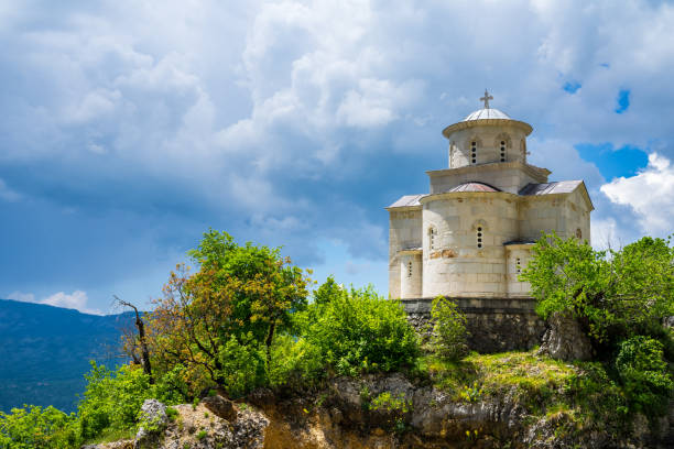 bonito nuevo edificio de la iglesia ortodoxa cerca del monasterio de ostrog con cielo dramático y sunhine en verano - ostrog fotografías e imágenes de stock