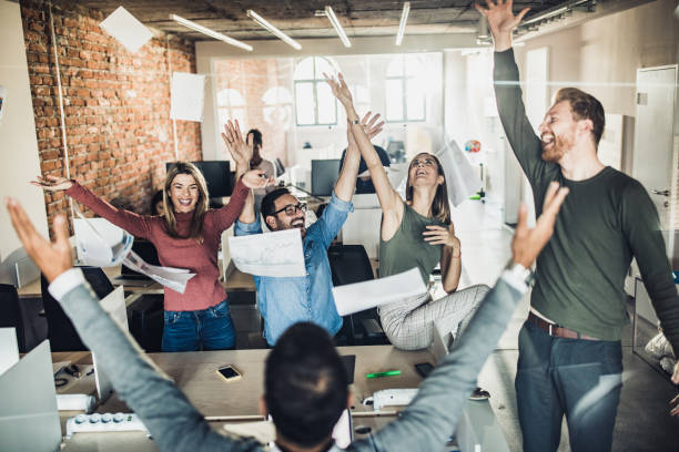 istock Large group of happy colleagues throwing reports in the office. 1163292782