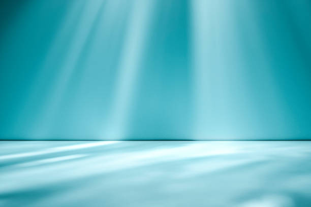 istock Beams of sunlight on a blue green background 1163292823