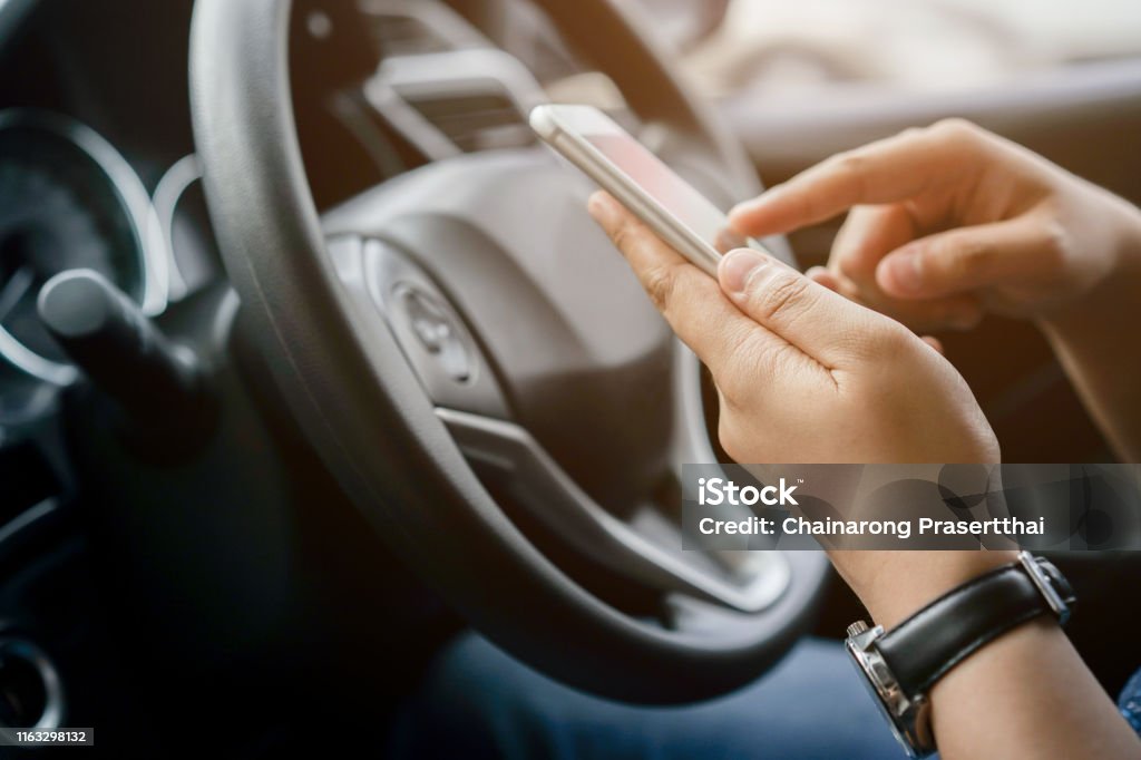 close up driver woman hand holding smartphone for using GPS navigation of travel destination and swipe for reading data on web browser or texting message online for contact while parking , journey lifestyle concept Car Stock Photo