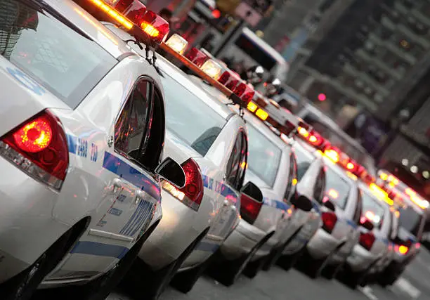 A long line of police squad cars ready to take of on it's daily "see we are securing New York" parade