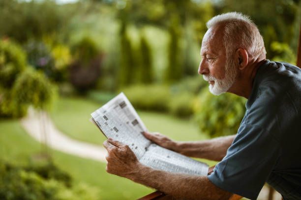istock Profile view of mature man reading newspapers on a terrace. 1163300585