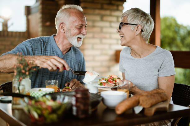 istock Happy mature couple talking while having breakfast on a balcony. 1163301290