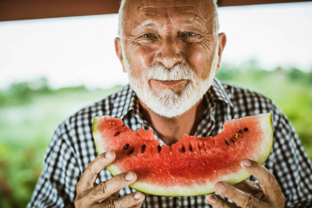 istock Smiling senior man enjoying in fresh watermelon. 1163301426