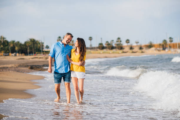 istock Couple in love walking down the beach 1163302654