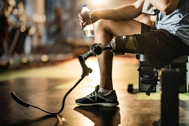 istock Unrecognizable amputee resting on water break in a gym. 1163304277