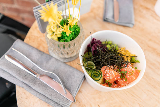 traditional hawaiian dish poke bowl with fork. hawaiian salmon fish with rice, radish,cucumber, tomato, sesame seeds and seaweeds. diet and useful fast food - poking prepared ahi tuna hawaiian culture imagens e fotografias de stock