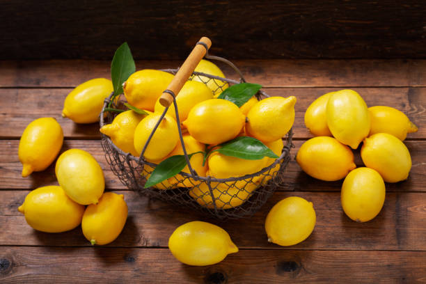 istock fresh lemons with leaves in a basket, top view 1163305363