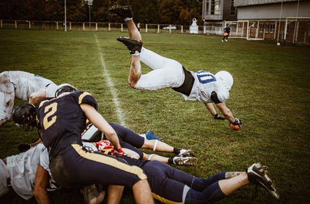istock American football quarterback passing through defense for a touchdown. 1163306597