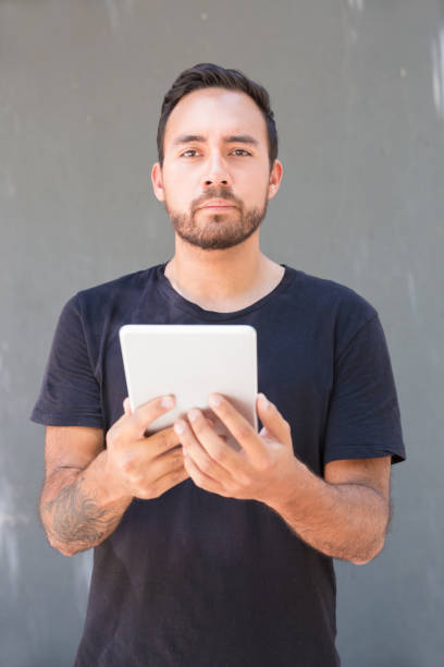 istock Confident man holding digital tablet and looking at camera 1163306769