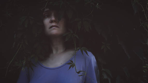istock Girl looking forward on dark nature background 1163307697