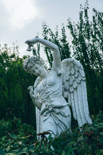 istock Green leaves and angel sculpture with wings 1163309149