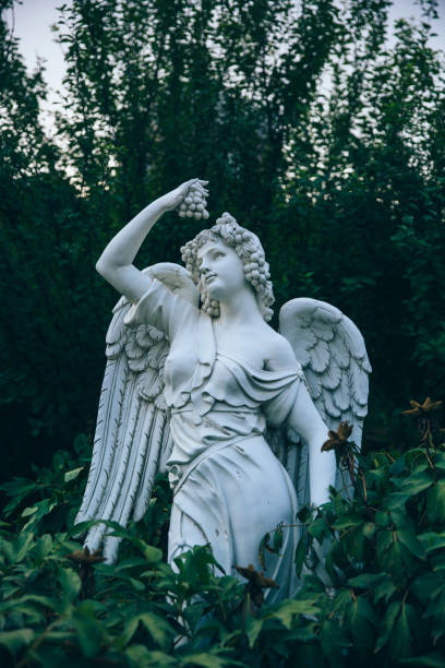 istock Green leaves and angel sculpture with wings 1163309151