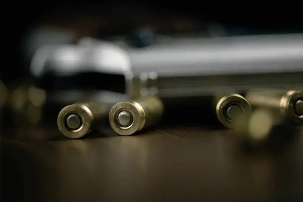 Photo of Gun and bullets on wood background