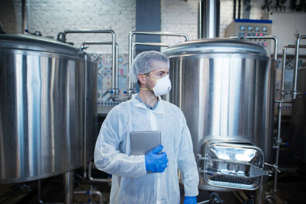 istock Technologist standing by factory production line. 1163311976