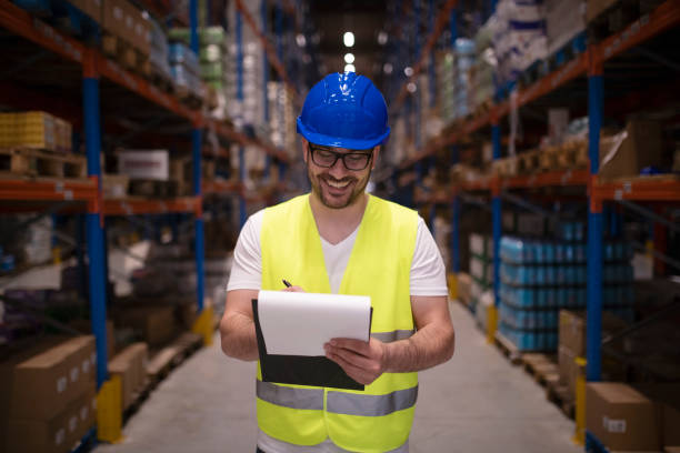 istock Warehouse worker writing report in large storage area. 1163312685