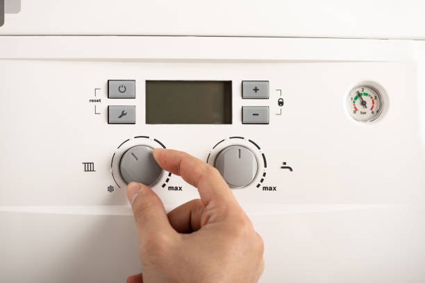 homem que gira sobre uma caldeira de gás de combi - boiler gas boiler thermostat control panel - fotografias e filmes do acervo