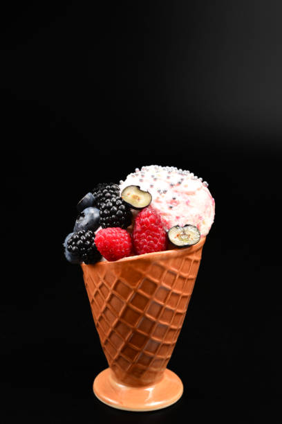 istock Ice cream with blueberries, blackberries and raspberries on a black background.  Copy space. 1163315292