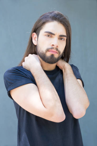 istock Serious bearded man with long hair posing outdoor. 1163317404