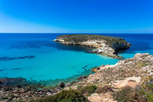 Lampedusa Island Sicily - Rabbit Beach and Rabbit Island Lampedusa “Spiaggia dei Conigli” with turquoise water and white sand at paradise beach. Mediterranean scrub with thyme and cardoon. Tabaccara Bay