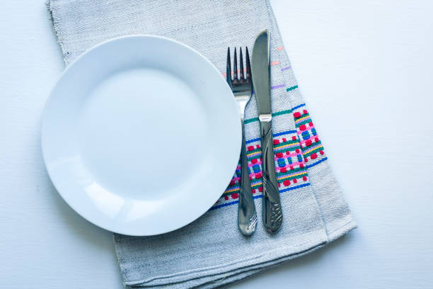 Empty blue ceramic plate with knife and fork close up, top view