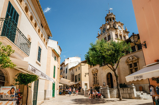 Alcudia, Mallorca, Spain - May 23, 2015: Architecture of Majorca. The tower with big clock of City town hall in Old Town of Alcudia, Mallorca, Balearic island, Spain