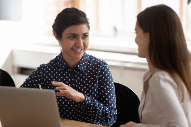 istock Smiling multiethnic girls talk studying at project together 1163323440