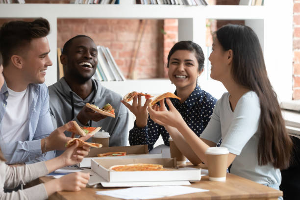 istock Overjoyed diverse students laugh having break enjoying pizza 1163323460