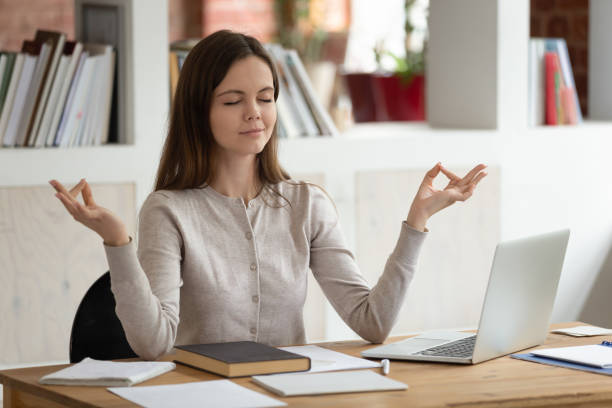 istock Peaceful girl distracted from studying meditating at workplace 1163323467