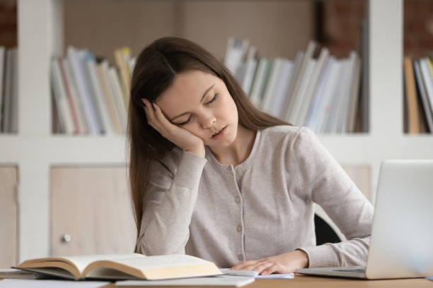 istock Tired girl student fall asleep studying at workplace 1163323469