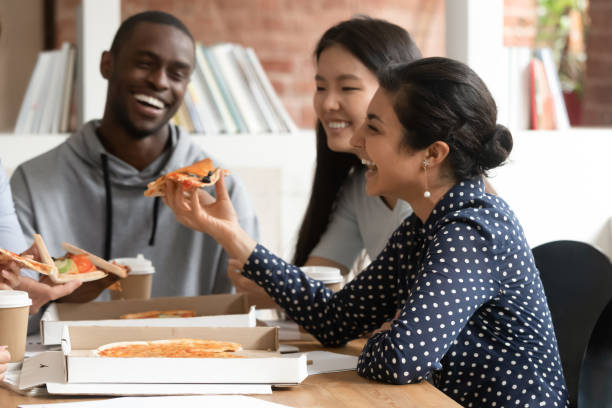 istock Happy multiracial young people have fun eating pizza 1163323470
