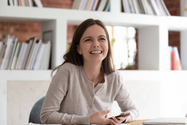 istock Smiling girl at desk have fun talking with someone 1163323474